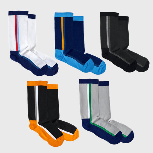 Five pairs of crew socks in different color combinations, each with a vertical stripe: white with red/blue, blue with yellow, black with gray, black with orange, and gray with green. The socks are arranged on a light background.