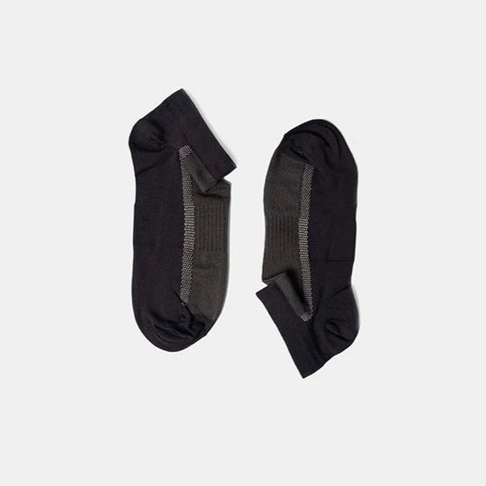 A pair of low-cut black and dark gray socks with a ribbed texture, laid flat on a plain light gray background.