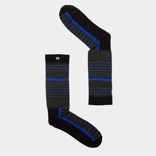 Two black socks with blue and gray horizontal stripes are arranged on a light gray background, one laid out vertically and the other horizontally to form an L shape.