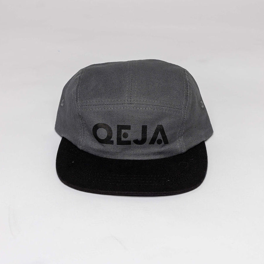 A gray and black five-panel cap with the word QEJA printed in black lettering on the front. The background is plain and white.